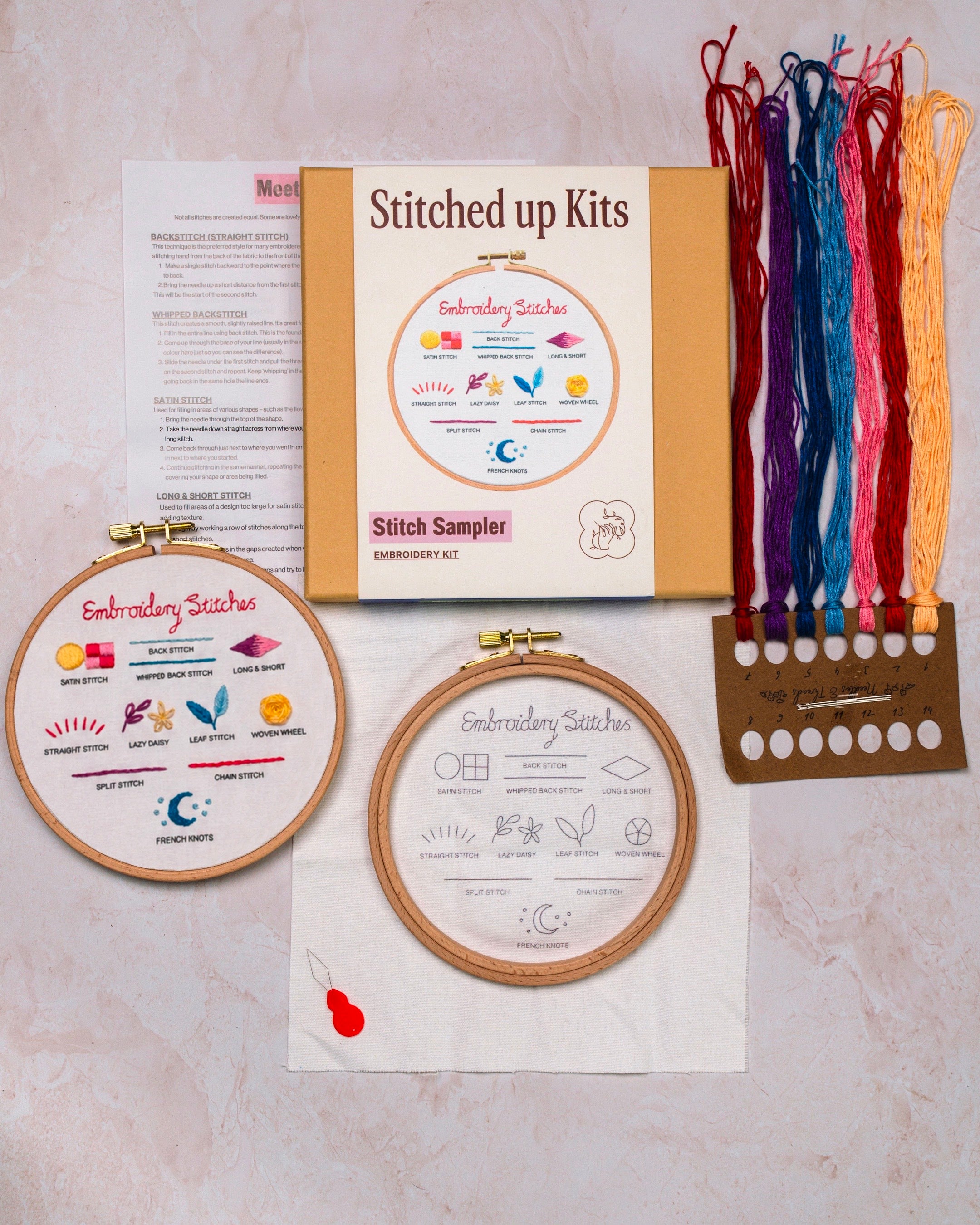 Embroidery kit with hoops, threads, and instructions on a neutral background