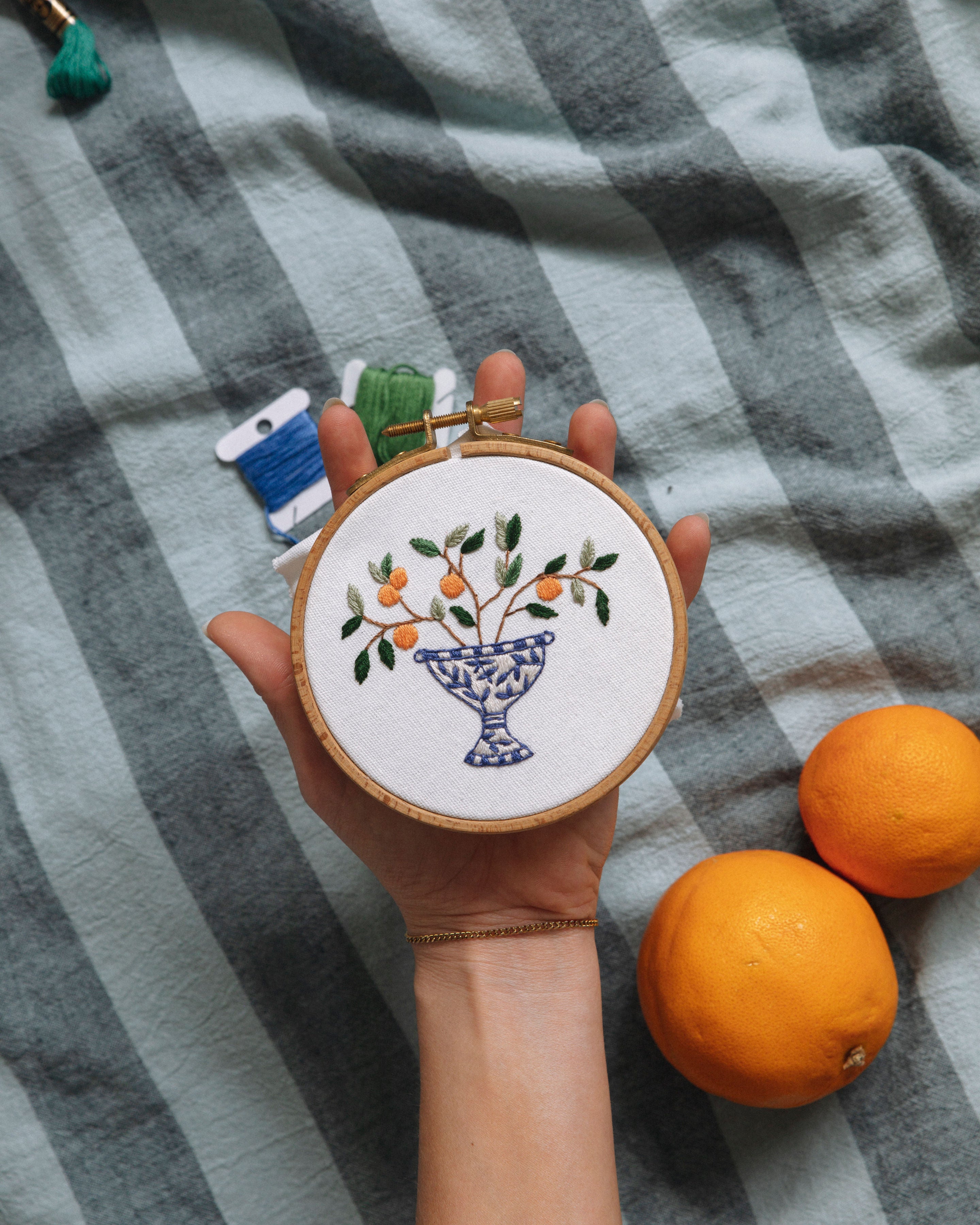 Mini Italian Collection featuring embroidered oranges in decorative vase, shown with thread spools and fresh oranges