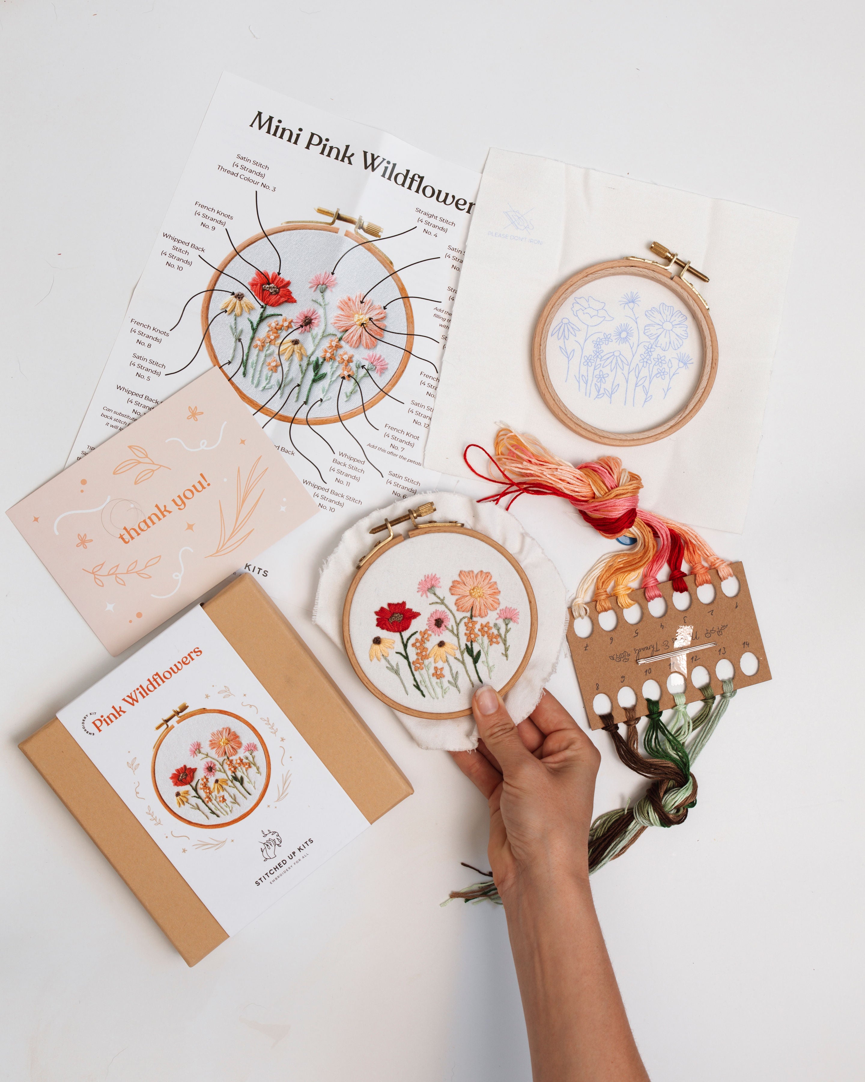 Mini Tabasco Chillies product showing colorful embroidery threads and floral stitching kit with hand holding embroidery hoop.