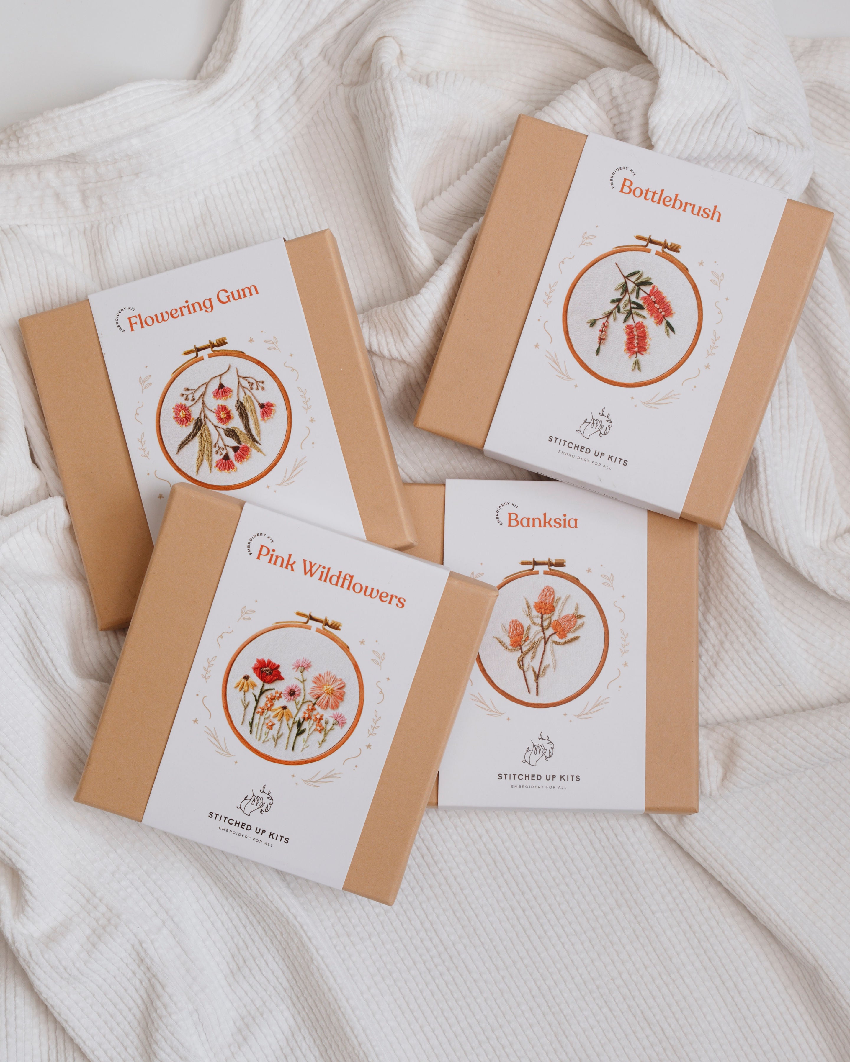 All 5 Mini Embroidery Kits featuring Australian native flowers displayed in kraft boxes with embroidery hoop designs on white covers