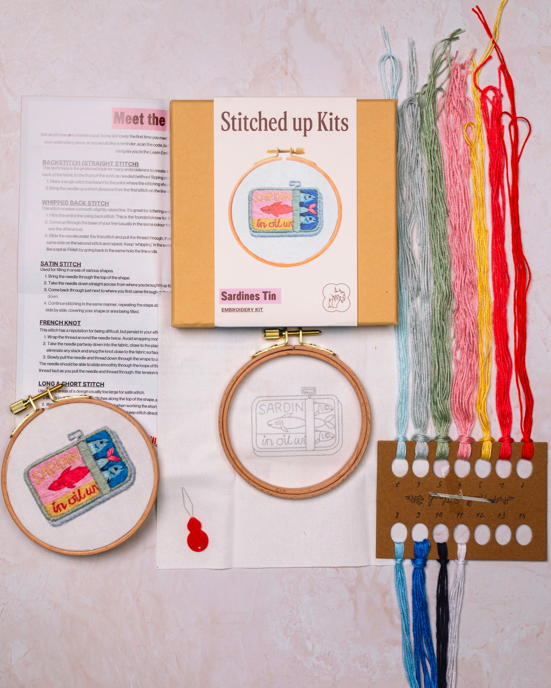 Embroidery kit with hoop, threads, and printed instructions on a light background