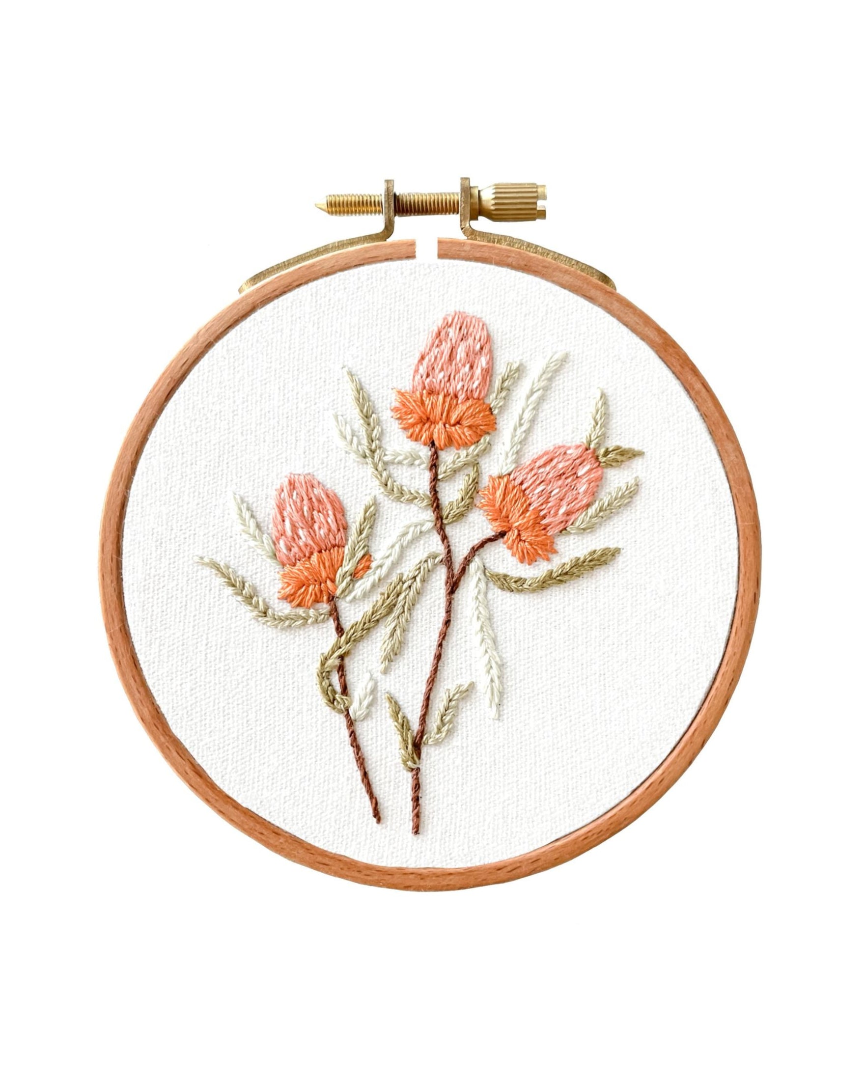 Mini Banksia embroidery artwork featuring delicate coral-colored native flowers with sage green leaves in wooden hoop frame