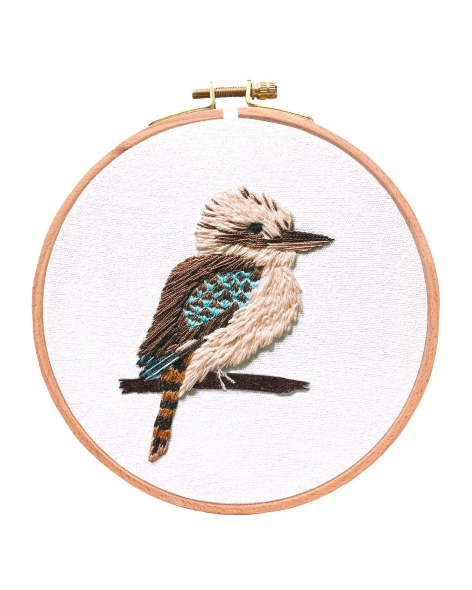 Kookaburra embroidered artwork in wooden hoop featuring detailed brown and turquoise bird stitching on white fabric