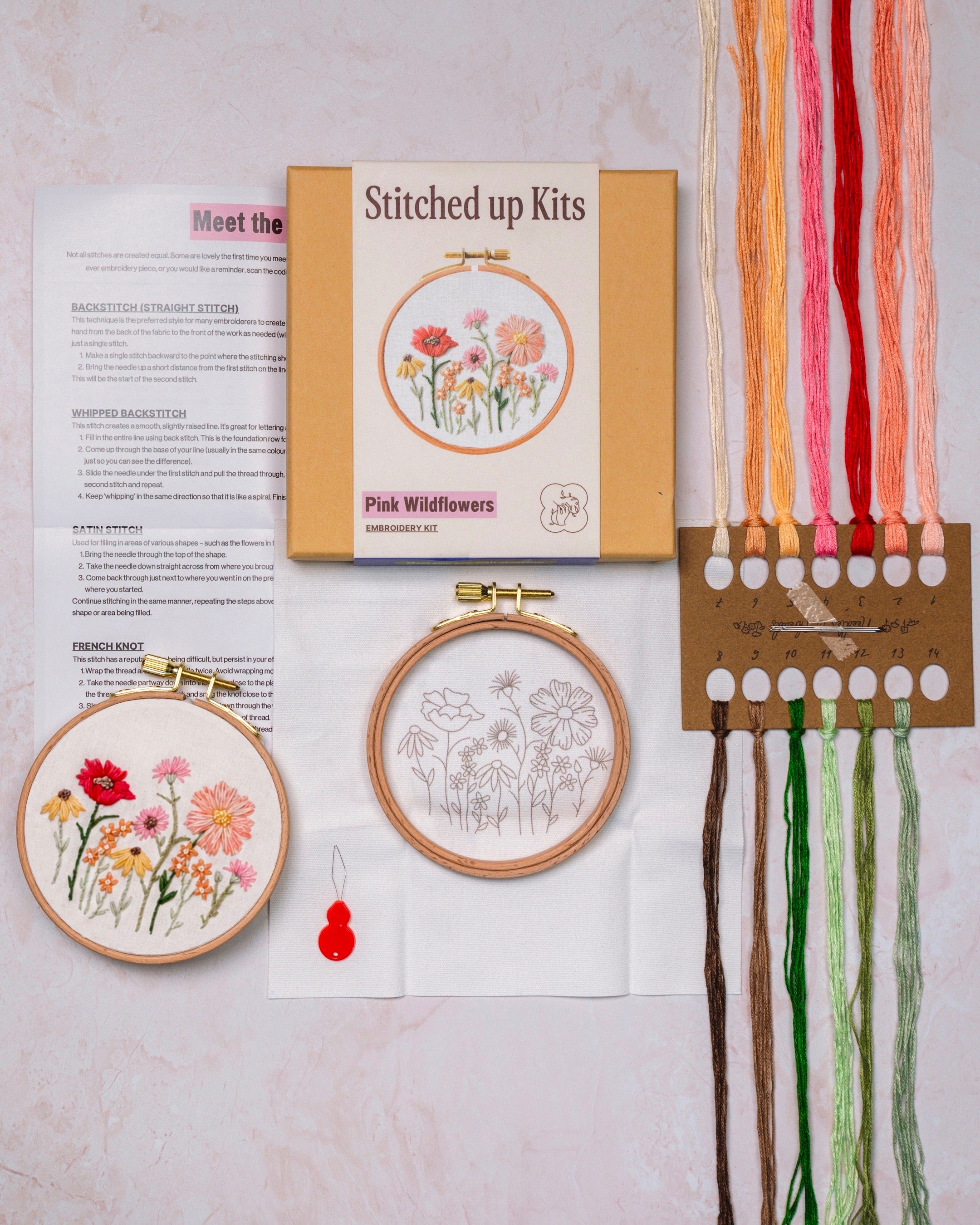 Embroidery kit with floral patterns, threads, and a box labeled 'Stitched up Kits'.
