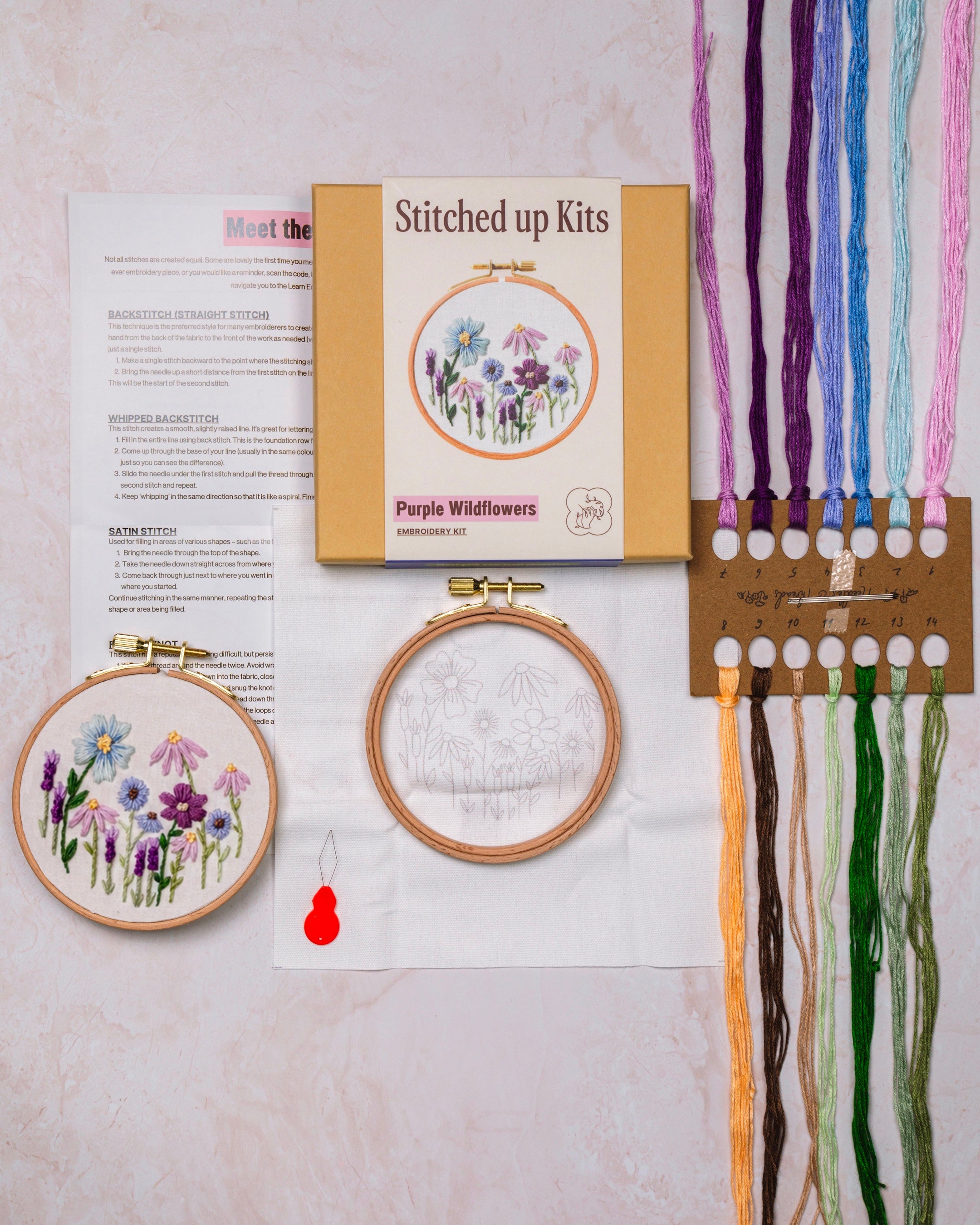 Embroidery kit with hoops, threads, and a printed pattern on a light background