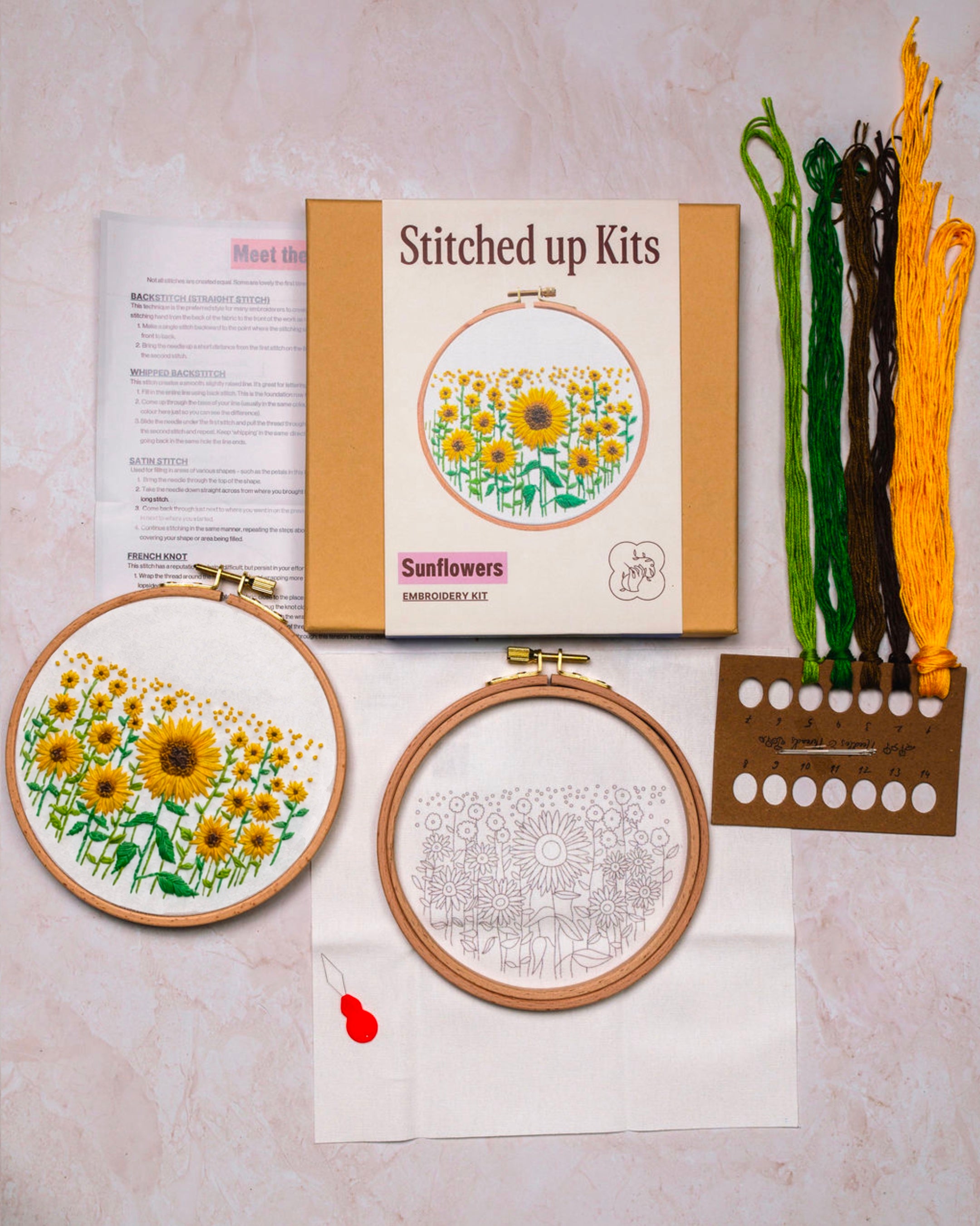 Flat lay of sunflowers embroidery kit with threads, hoop and fabric